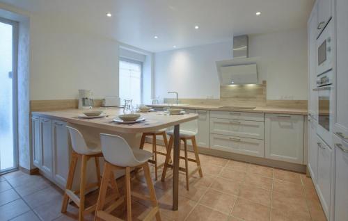 a kitchen with a table and some chairs in it at Maison Proche Port Et Plage in Saint-Vaast-la-Hougue