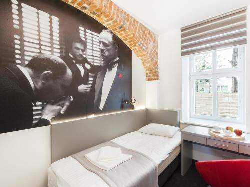 a bedroom with a poster of three men at Cinema Hostel in Poznań