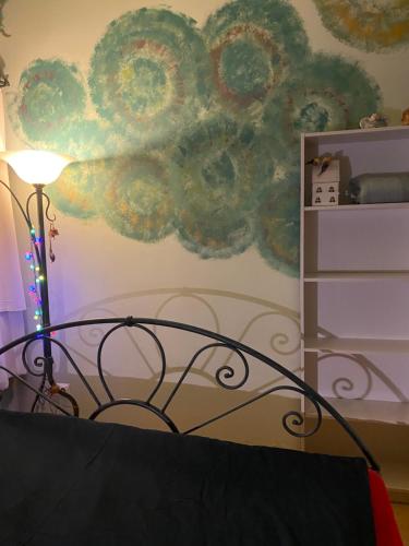 a bedroom with a cloud mural on the wall at Apartament z kotem in Bielsko-Biała