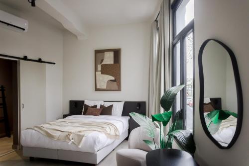 a bedroom with a bed and a large mirror at ROMY ANTWERP Sint-Jansvliet in Antwerp