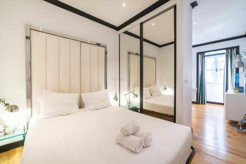 a bedroom with a large white bed with towels on it at Bliss Lisbon Apartments - Bairro Alto in Lisbon