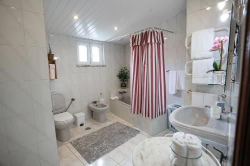a bathroom with a sink and a toilet and a tub at Casa Aguarela in São Romão