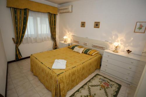 a bedroom with a bed and a dresser in it at Casa Aguarela in São Romão