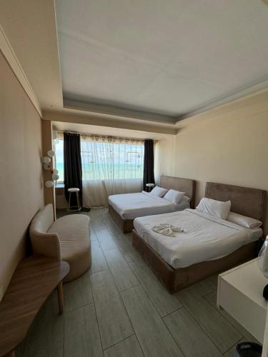 a hotel room with two beds and a chair at Alex inn Rooms in Alexandria