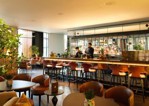 a bar in a restaurant with people standing behind the bar at The Grove in Watford