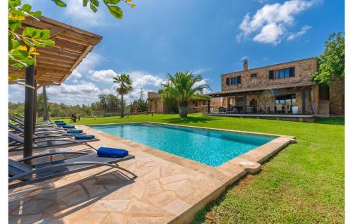 a swimming pool with lounge chairs in front of a house at Es Sequer in Felanitx