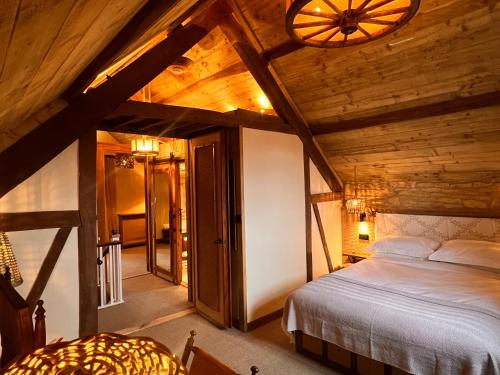a bedroom with a bed in a wooden ceiling at Dovecote Cotswold Cottages in Chipping Norton