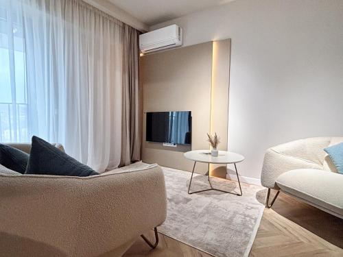 a living room with a couch and a table at YANG 23rd Floor Panoramic View & King Bed, Parkin in Cluj-Napoca