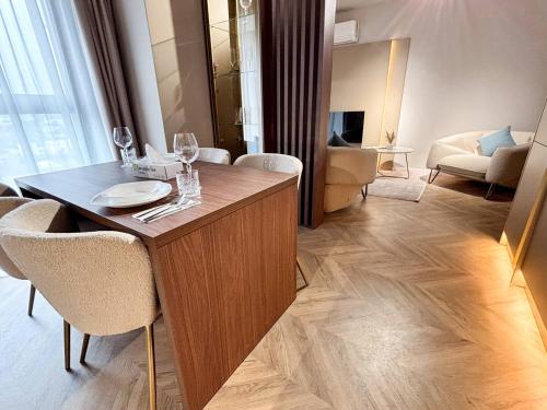 a living room with a table with wine glasses on it at YANG 23rd Floor Panoramic View & King Bed, Parkin in Cluj-Napoca