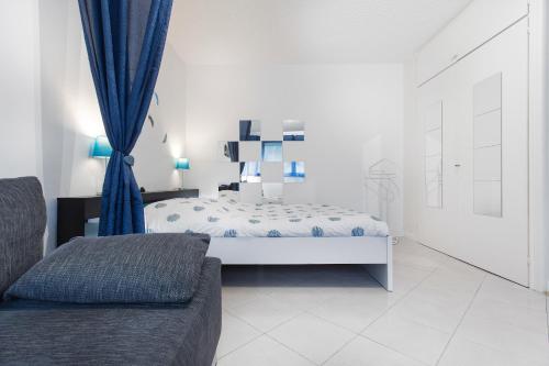 a bedroom with a bed with blue curtains and a couch at Ancely Studio Aséptisé in Toulouse