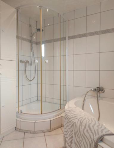 a bathroom with a shower and a tub at Hillis Ferienwohnung Saarland in Sankt Ingbert