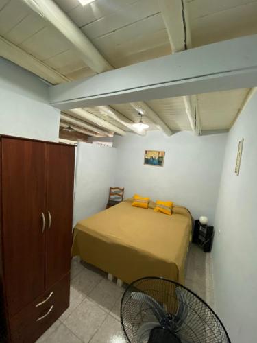 ein Schlafzimmer mit einem Bett mit orangefarbenen Kissen in der Unterkunft OLENA in Perdriel