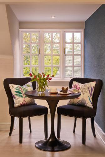 a dining room with a table and two chairs at Langshott Manor - Luxury Hotel Gatwick in Horley