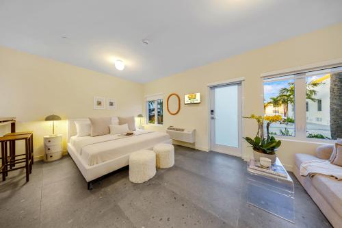 a large bedroom with a white bed and a couch at El Jardin by Renzzi in Miami