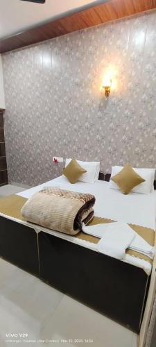 a bedroom with a large bed with white sheets and pillows at ANAND LOK VARANASI in Varanasi
