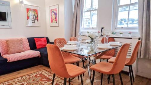 a dining room with a table and chairs and a couch at Spacious Detached Houses with FREE PARKING near Little Venice, Paddington & Hyde Park by Staylio London in London