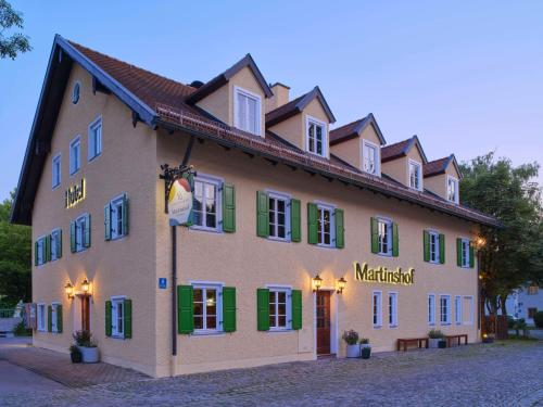 a large building with green shutters on a street at Classik Hotel Martinshof, Messe München in Munich