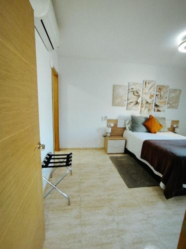 a bedroom with a bed and a chair in it at Las Salinas in Roquetas de Mar