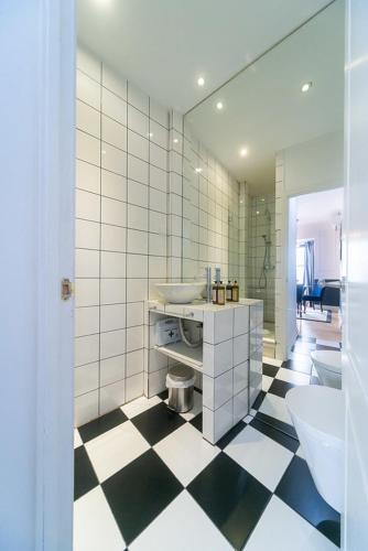 a bathroom with a black and white checkered floor at Bliss Lisbon Apartments - Bairro Alto in Lisbon