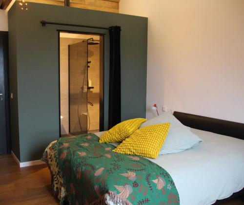 a bedroom with a bed with yellow pillows at B&B Even Heukelom - Kamer 2 in Afferden
