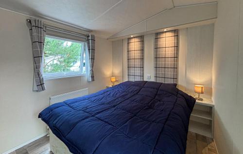 a bedroom with a large blue bed with a window at Europarcs Zuiderzee Berkel-4 #363 in Biddinghuizen