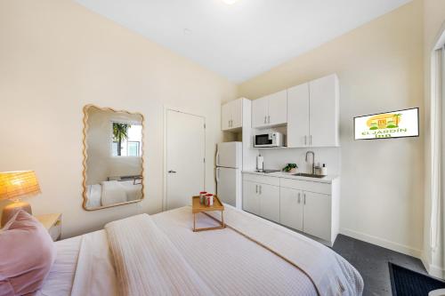 a white room with a bed and a kitchen at El Jardin by Renzzi in Miami