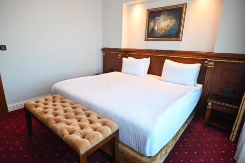 a bedroom with a large bed with a tufted headboard at Hotel Porta 26 in Skopje