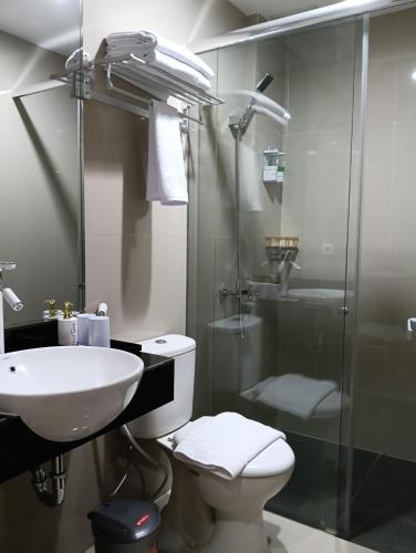 a bathroom with a sink and a toilet and a shower at Sunflower Hotel Syariah near Juanda Airport in Dares