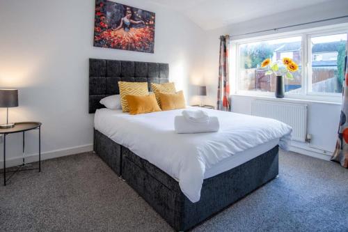 a bedroom with a large bed with yellow pillows and a window at Gellionen - 2 Bedroom House - Clydach in Clydach