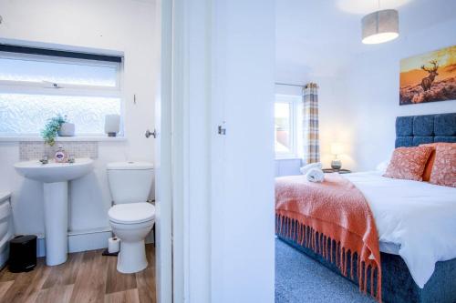 a bedroom with a bed and a sink and a toilet at Gellionen - 2 Bedroom House - Clydach in Clydach