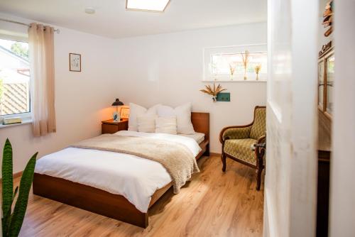 a bedroom with a bed and a chair at Ferienhaus Peenegrün in Jarmen