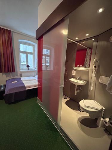 a bathroom with a bed and a toilet and a sink at Pension Stadthalle in Vienna