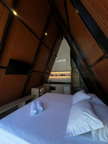 a bedroom with a large bed with two white pillows at Âmbar Chalés 2 in Ametista do Sul