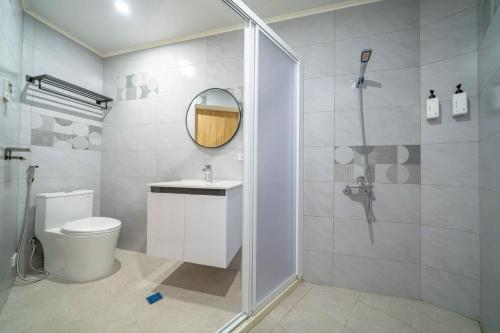 a bathroom with a shower and a toilet and a mirror at Yunheyue B&B in Suao