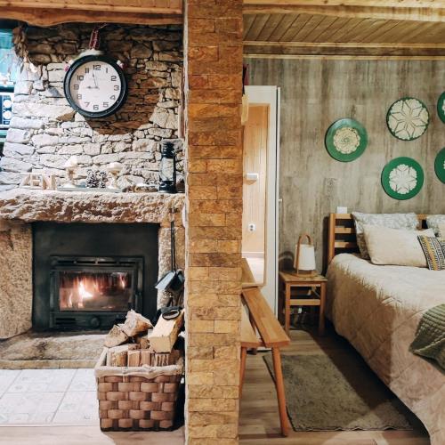 ein Schlafzimmer mit Steinkamin, Bett und Uhr in der Unterkunft Casa do Azevim in Gavieira