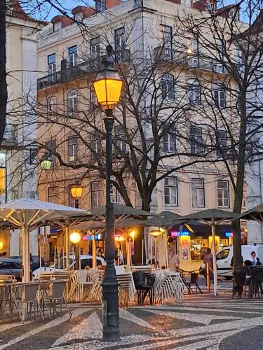 un lampione con tavoli e sedie di fronte a un edificio di Lisbon Calling a Lisbona