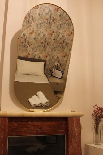 a mirror above a bed with two towels at Alimena Retrò Rooms in Cosenza