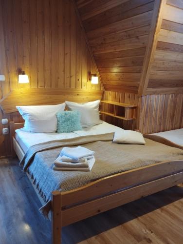 a bed in a room with wooden walls at DW Łomnica in Białka Tatrzańska
