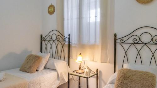 a bedroom with a bed and a lamp and a window at Villa Quevedo Torrox by Ruralidays in Torrox
