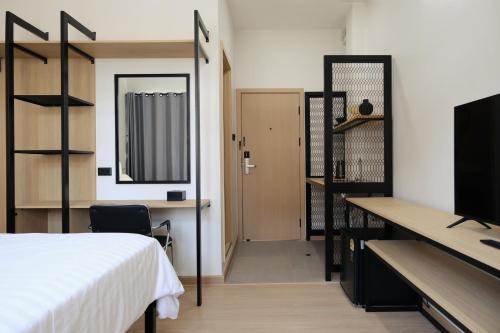 a bedroom with a bed and a desk and a mirror at Baan Noppadol in Bangkok