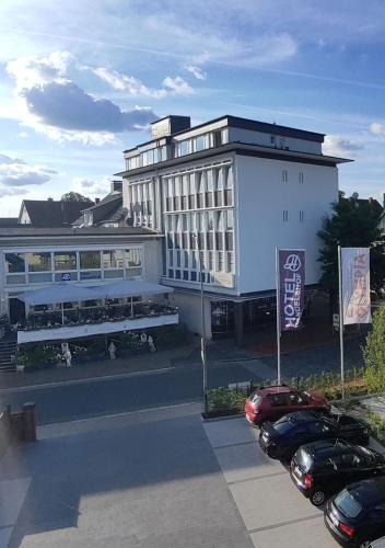 a large white building with cars parked in front of it at Hotel Handelshof in Bünde