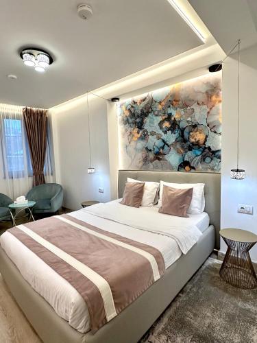 a bedroom with a large bed with a painting on the wall at House4You - Blanari in Bucharest