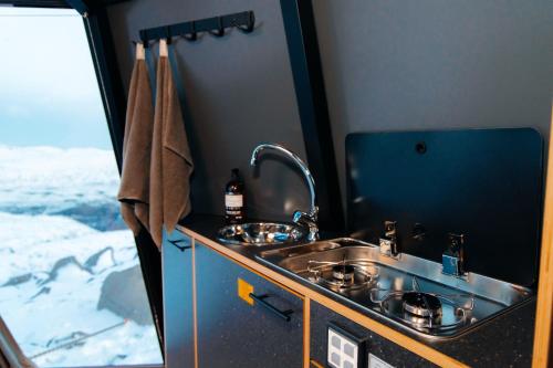 a kitchen with a sink and a window at Adventure Stay in Vík