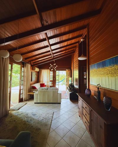 a large living room with a couch and a television at EcoVibe House Florianópolis in Florianópolis