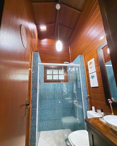 a bathroom with a shower and a toilet and a sink at EcoVibe House Florianópolis in Florianópolis