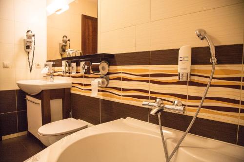 y baño con bañera, lavabo y aseo. en Franko hotel, en Zvolen