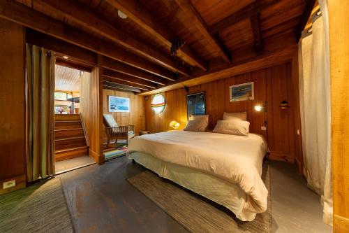 a bedroom with a bed in a wooden room at Péniche de charme, Avignon, Provence in Villeneuve-lès-Avignon
