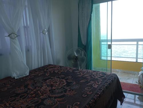 a bedroom with a bed and a fan and a window at J U N Q U E I R A i in Mangaratiba
