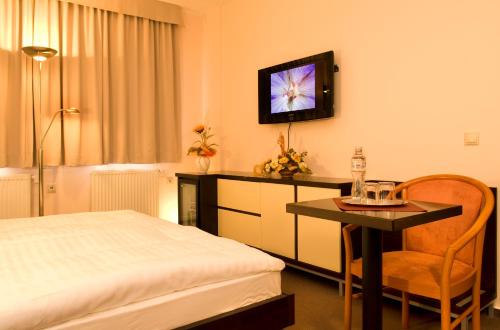 a hotel room with a bed and a table and a television at Franko hotel in Zvolen