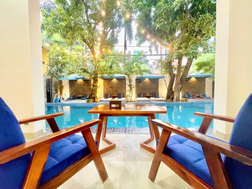 a table and two chairs in front of a swimming pool at SkyVilla BKK - Pool & Chill - Laundry included in Phnom Penh